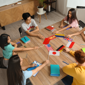 four people sitting st a table holding country flags signifying communicating skills