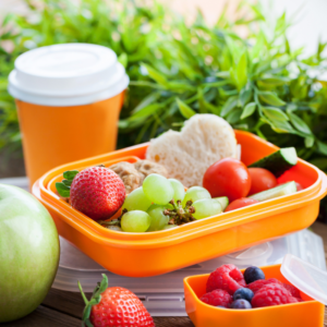 NUTRITIOUS LUNCH organge lunchbox with grapes strawberries, and cucumber